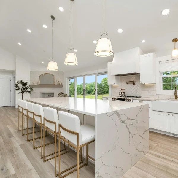 Clean kitchen with a marble island and white cabinets