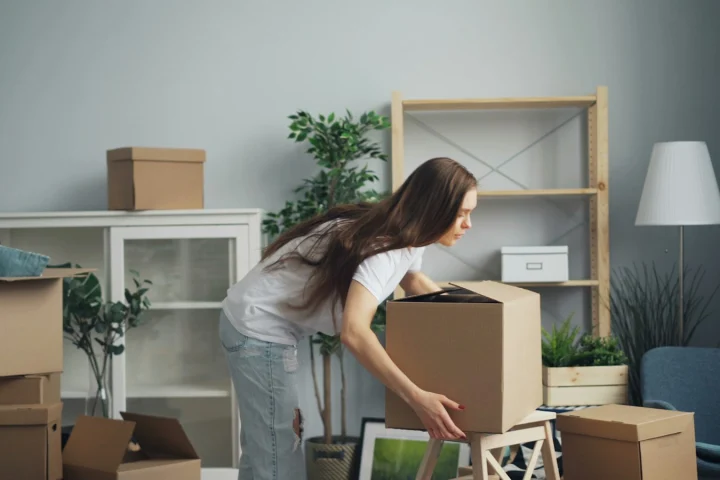 Woman packing moving boxes in an apartment